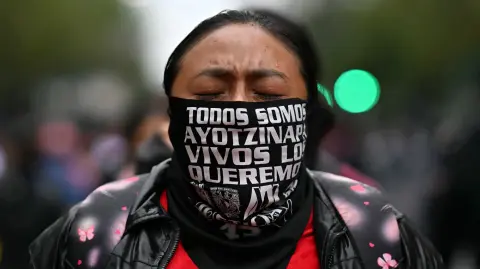 Mujer participa en la conmemoración del 11.º aniversario de la desaparición de 43 estudiantes de Ayotzinapa.