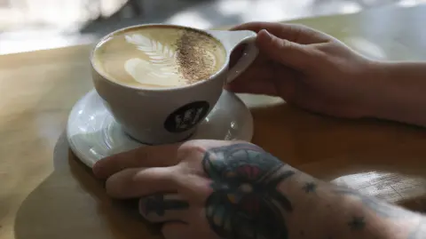Una persona toma café en una cafetería de Nueva York.