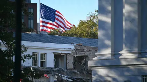 Heavy machinery tears down a section of the East Wing of the White House as construction begins on President Donald Trumps planned ballroom, in Washington, DC, on October 20, 2025. US President Donald Trump held a glitzy dinner October 15, 2025 to thank billionaires and top companies for donating to the new $250 million ballroom he is building at the White House. The guests included representatives from tech firms like Amazon, Apple, Meta, Google, Microsoft and Palantir and defense giant Lockheed Martin, according to US media citing a White House guest list. (Photo by Pedro UGARTE / AFP)