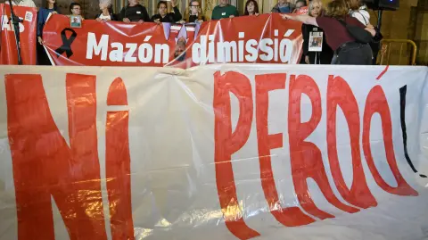 Demonstrators hold up banners and photographs of victims during a protest demanding for justice for the victims of last year's devastating floods in Valencia on November 3, 2025. The leader of Spain's flood-hit Valencia region, Carlos Mazon, who has faced fierce scrutiny over his handling of the October 29, 2024 catastrophe that killed more than 230 people, announced his resignation earlier today (Photo by Jose JORDAN / AFP)