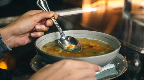 A woman in a cafe eats a low-calorie vegetable soup, the concept of vegetarianism, veganism and healthy eating.