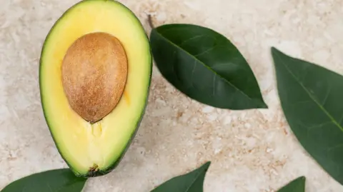 Sliced fresh delicious avocado on marble background. High quality photo