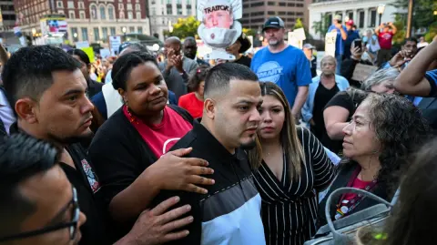 (FILES) Salvadoran migrant and US resident Kilmar Abrego Garcia walks with his wife Jennifer Vasquez as he arrives at a US Immigration and Customs Enforcement (ICE) field office in Baltimore, Maryland, on August 25, 2025. A US federal judge on December 11, 2025, ordered the immediate release of Kilmar Abrego Garcia, a Salvadoran man who was wrongly deported in March and then returned to the United States after months of legal battles and detained again. The case of Abrego Garcia, a Maryland resident married to an American woman, has become a lightning rod for those opposed to President Donald Trump's efforts to carry out mass deportations across the country. (Photo by ROBERTO SCHMIDT / AFP)