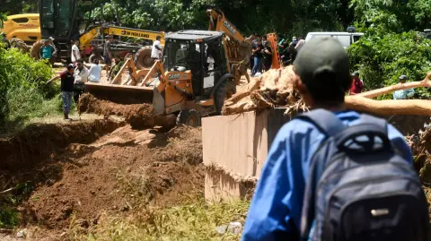 Heavy machinery works at the site where a bridge collapsed after the Pirai River overflowed due to heavy rains in El Torno, Santa Cruz department, Bolivia, on December 14, 2025. The unusual overflow of the Pirai River in Santa Cruz department mainly affected the towns of El Torno and La Guardia, where families were trapped, some even on the roofs of their homes. (Photo by Rodrigo URZAGASTI / AFP)