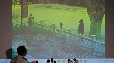 Providence Police Chief Colonel Oscar Perez looks at a new video released of the possible shooter at Brown University, during a press conference in Providence, Rhode Island, U.S., December 15, 2025.   REUTERS/Brian Snyder