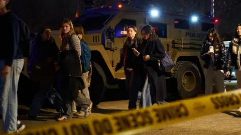Evacuated Brown University students arrive at a temporary family reunification site at Nelson Fitness Center at Brown University in Providence, Rhode Island, on December 13, 2025. Hundreds of police officers hunted Sunday for a gunman who killed two people and wounded nine others at Brown University, plunging the eastern US campus into lockdown. (Photo by Bing Guan / AFP)