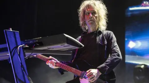 Perry Bamonte, conocido como "Teddy", que se convirtió en miembro de pleno derecho de The Cure en 1990.

Para más información del tema, visita: https://www.eleconomista.com.mx/arteseideas/perry-bamonte-guitarrista-tecladista-the-cure-fallecio-65-anos-20251226-792880.html 

¡Síguenos en nuestras redes sociales para mantenerte informado!

Twitter: https://twitter.com/eleconomista 
Facebook: https://www.facebook.com/ElEconomista.mx
Instagram: https://www.instagram.com/eleconomistamx
LinkedIn: https://www.linkedin.com/company/el-economista/

#ElEconomista #TheCure #PerryBamonte