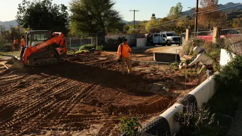 Obreros de la construcción comienzan a construir los cimientos de una casa destruida por el incendio Eaton.