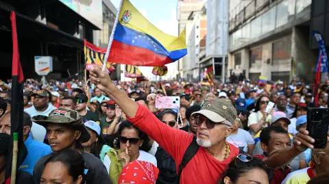 Un partidario del derrocado presidente de Venezuela, Nicolás Maduro, ondea una bandera venezolana durante una manifestación para ver una sesión de la Asamblea Nacional en una pantalla grande en Caracas el 5 de enero de 2026.