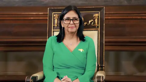 This handout picture released by the Miraflores Palace press office shows Venezuela's interim President Delcy Rodriguez gesturing during an oath ceremony at the National Assembly in Caracas on January 5, 2026. Venezuela's parliament swore in Delcy Rodriguez as interim president on January 5, two days after US forces seized her predecessor Nicolas Maduro to face trial in New York. Members of the new National Assembly offered their full backing to Rodriguez -- who had been Maduro's vice president -- and reelected her brother Jorge Rodriguez as parliament head. (Photo by Marcelo Garcia / Miraflores press office / AFP) / RESTRICTED TO EDITORIAL USE - MANDATORY CREDIT "AFP PHOTO /  MIRAFLORES PALACE PRESS OFFICE / MARCELO GARCIA" - HANDOUT - NO MARKETING NO ADVERTISING CAMPAIGNS - DISTRIBUTED AS A SERVICE TO CLIENTS