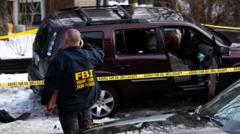 Elementos del FBI trabajan en la escena luego de un presunto tiroteo por parte de un agente de ICE contra una mujer durante operaciones policiales federales en Minneapolis, Minnesota.