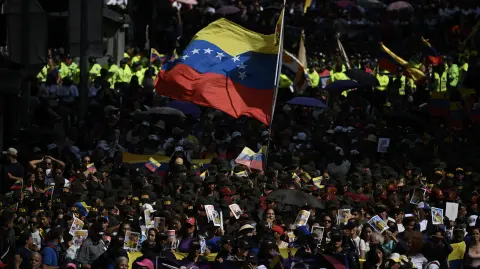 people attend a rally in support of ousted Venezuela's President Nicolas Maduro and his wife Cilia Flores in Caracas on January 6, 2026. Venezuela's interim president Delcy Rodriguez insisted on January 6, no foreign power was governing her country, after US President Donald Trump said Washington would "run" it pending a transition after ousting her predecessor. (Photo by Federico PARRA / AFP)
