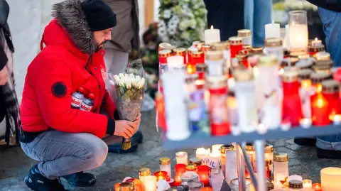Los asistentes se reúnen en señal de luto, colocando mensajes, velas y flores en un lugar conmemorativo frente al bar “Le Constellation”.
