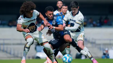 Soccer Football - Liga MX - Pumas UNAM v Queretaro - Estadio Olimpico Universitario, Mexico City, Mexico - January 11, 2026  Pumas UNAM's Adalberto Carrasquilla and Pumas UNAM's Cesar Garza in action with Queretaro's Lucas Rodriguez REUTERS/Eloisa Sanchez