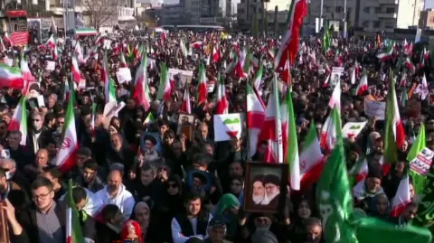 This grab taken from handout video footage released by Iran Press on January 12, 2026, shows pro-government demonstrators rallying in Enghelab (Revolution) Square in central Tehran in a show of support for the Islamic Republic. Iranian authorities on January 12, 2026, sought to regain control of the streets with mass nationwide rallies in the wake of protests on a scale unprecedented in recent years, as alarm grew over a deadly crackdown. (Photo by IRAN PRESS / AFP) / - Israel OUT / - ISRAEL OUT / XGTY/RESTRICTED TO EDITORIAL USE - MANDATORY CREDIT AFP -  SOURCE: IRAN PRESS - NO MARKETING - NO ADVERTISING CAMPAIGNS -  DISTRIBUTED AS A SERVICE TO CLIENTS - NO RESALES- NO ACCESS ISRAEL MEDIA/PERSIAN LANGUAGE TV STATIONS OUTSIDE IRAN/STRICTLY NO ACCESS BBC PERSIAN/ VOA PERSIAN/MANOTO-1 TV/IRAN INTERNATIONAL / RADIO FARDA /NO RADIO FARDA /