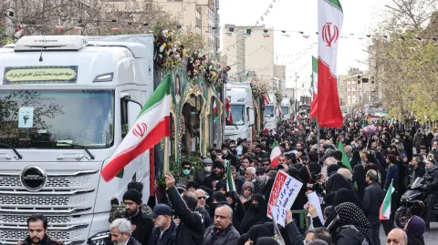 Iranians attend the funerals of security forces personnel killed in recent protests in Tehran on January 14, 2026. A funeral ceremony began in Tehran on January 14, 2026 for over 100 members of the security forces and other "martyrs" killed in the wave of protests that has rocked the Islamic republic, state television said. (Photo by ATTA KENARE / AFP)