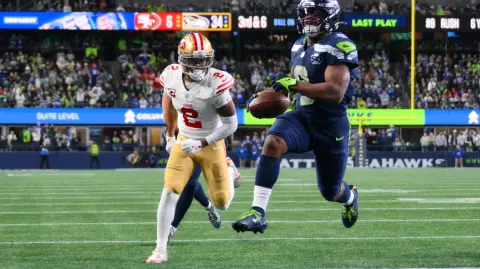 Jan 17, 2026; Seattle, WA, USA; Seattle Seahawks running back Kenneth Walker III (9) carries the ball for a touchdown as San Francisco 49ers cornerback Deommodore Lenoir (2) trails on the play during the second half in an NFC Divisional Round game at Lumen Field. Mandatory Credit: Steven Bisig-Imagn Images
