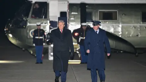 US President Donald Trump heads to board Air Force One before departing Joint Base Andrews in Maryland on January 20, 2026. Trump is heading to the Swiss ski resort of Davos to attend the World Economic Forum (WEF). (Photo by Mandel NGAN / AFP)