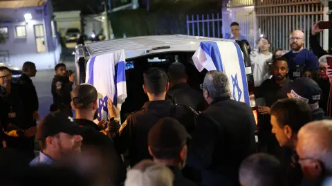 Israeli police officers pay their respects outside of the Abu Kabir Forensic Institute, as the body of last Israeli  hostage arrives in Tel Aviv on January 26, 2026. The remains of the last hostage held in Gaza, Ran Gvili, were brought back to Israel on January 26, closing the chapter on a painful saga that has kept Israeli society on edge ever since Hamas's unprecedented October 7, 2023 attack. (Photo by ilia yefimovich / AFP)