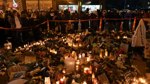 People mourn at a makeshift memorial in the area where Alex Pretti was shot dead by federal immigration agents in Minneapolis, Minnesota, on January 26, 2026. On January 24, federal agents shot and killed Alex Pretti, a 37-year-old ICU nurse, while scuffling with him on an icy roadway in Minneapolis, less than three weeks after an immigration officer fired on Renee Good, also 37, killing her in her car. The fatal shootings has reignited accusations that federal agents enforcing US President Donald Trump's militarized immigration crackdown are inexperienced, under-trained and operating outside law enforcement norms. (Photo by Octavio JONES / AFP)