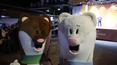 Milo (L) and Tina, the mascots of the Milano Cortina Olympic and Paralympic Games are pictured in Cortina d'Ampezzo before the last torch relay of the Olympic flame in the city, on January 26, 2026. (Photo by Odd ANDERSEN / AFP)