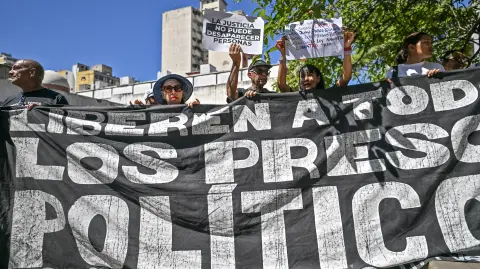 Relatives of political prisoners demonstrate demanding their release with a banner reading "Liberate all political prisoners" and a sign reading "Justice cannot disappear people" outside the court in Caracas on February 5, 2026. Venezuelas Parliament has been debating since Thursday a draft amnesty law that covers those accused of treason, terrorism, and incitement to hatred, offenses that were typically brought against political prisoners. (Photo by Juan BARRETO / AFP)