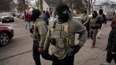 Miembros de la comunidad reaccionan ante agentes federales de inmigración que realizan tareas de control migratorio en Minneapolis , Minnesota.