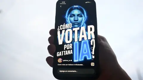 A cellphone shows "Gaitana", an artificial intelligence represented on social media as a woman with blue skin and a feather loincloth, that will participate as a candidate for the Colombia's legislative elections in Bogota on February 12, 2026. The artificial intelligence "Gaitana" defines itself as an "environmentalist" and "animal rights activist", and will appear on one of the ballots as an independent candidate for one of the seats reserved for indigenous communities in Colombia's legislative elections on March 8, 2026. (Photo by Raul ARBOLEDA / AFP)