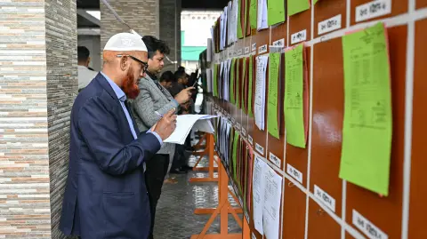 Miembros de los medios de comunicación revisan documentos de los resultados electorales preliminares en la oficina de la Comisión Electoral en Daca el 13 de febrero de 2026 (tiempo local).