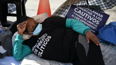 Un familiar de un preso político yace en el suelo durante una protesta frente a la prisión Zona 7 de la Policía Nacional Bolivariana.
