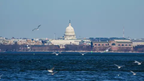 El Capitolio de EU se ve al otro lado del río Potomac desde Alexandria, Virginia.