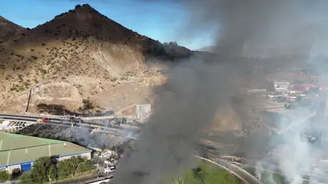 Aerial view of smoke rising from the site of a gas-transport truck explosion in Santiago on February 19, 2026. The explosion of a gas-transport truck killed at least four people and left 10 injured in Santiago on February 19, authorities said. (Photo by STR CHILE / AFP)