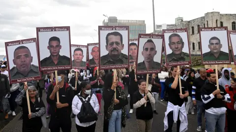 Personas sostienen retratos de soldados muertos en el ataque estadounidense a Venezuela y la captura del presidente Nicolás Maduro.