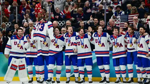 Milano Cortina 2026 Olympics - Ice Hockey - Men's Victory Ceremony - Milano Santagiulia Ice Hockey Arena, Milan, Italy - February 22, 2026. Gold medalists United States hold up the jersey of the late John Gaudreau as they celebrate with their medals during the ceremony REUTERS/Marton Monus
