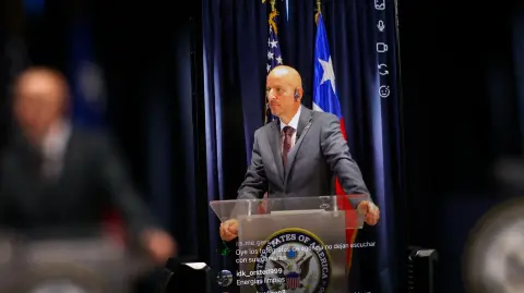 Un teléfono móvil transmite en vivo un discurso del embajador de Estados Unidos en Chile, Brandon Judd.