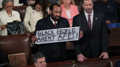 WASHINGTON, DC - FEBRUARY 24: Rep. Al Green (D-TX) holds up a sign as Trump delivers his State of the Union address during a Joint Session of Congress at the U.S. Capitol on February 24, 2026, in Washington, DC. Trump delivered his address days after the Supreme Court struck down the administration's tariff strategy and amid a U.S. military buildup in the Persian Gulf threatening Iran.   Chip Somodevilla/Getty Images/AFP (Photo by CHIP SOMODEVILLA / GETTY IMAGES NORTH AMERICA / Getty Images via AFP)