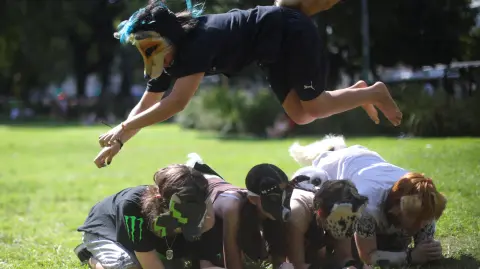 A person jumps over others while walking on all fours during a gathering of teenagers who identify as "Therians," a subculture whose members adopt animal characteristics, in Buenos Aires, Argentina, February 22, 2026. REUTERS/Tomas Cuesta