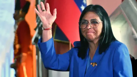 Venezuela's interim president Delcy Rodriguez waves after signing the amnesty law approved by the National Assembly at the Miraflores Palace in Caracas on February 19, 2026. Venezuela's Parliament unanimously approved on February 19 a historic amnesty law that is expected to lead to the release of hundreds of political prisoners after 27 years of Chavismo. (Photo by Juan BARRETO / AFP)
