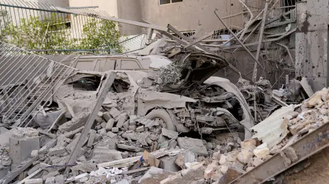 Escombros que cubren un vehículo destruido tras un ataque con misiles en un barrio de la capital iraní, Teherán.