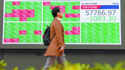 Un hombre camina frente al tablero de cotizaciones Nikkei, hoy en Tokio.