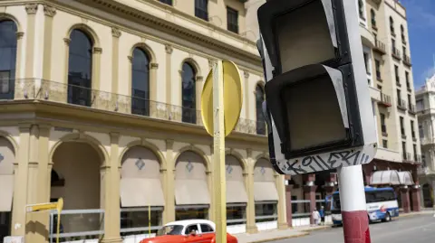 A car drives past a traffic light that is out due to a power cut in Havana on March 4, 2026. (Photo by YAMIL LAGE / AFP)