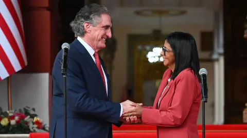 La presidenta interina de Venezuela, Delcy Rodríguez, estrecha la mano del secretario del Interior de Estados Unidos, Doug Burgum, después de su reunión en el Palacio Presidencial de Miraflores.