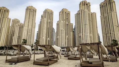 Empty beds are pictured before high-rise buildings along a beach at Jumeirah Beach Residence (JBR) in Dubai on March 11, 2026. Iran said on March 11 that it was ready for a long war of attrition that would "destroy" the world economy, after firing on two commercial ships and threatening any vessels from the US or its allies. (Photo by Fadel SENNA / AFP) /