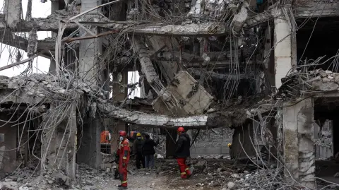 Rescue workers stand amid the rubble of a destroyed residential building in Tehran on March 12, 2026. The United States and Israel started striking Iran on February 28, killing the Iranian supreme leader and top military leaders, and prompting authorities to retaliate with strikes on Israel and across the Gulf. (Photo by AFP) /