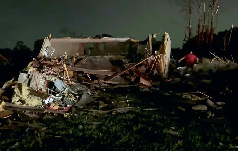 Residentes locales buscan entre los daños causados por el tornado.
