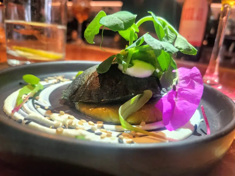 Quesadilla de Machaca estilo chilorio, elaborada con queso Oaxaca y una salsa esmeralda de aguacate con pipícha.