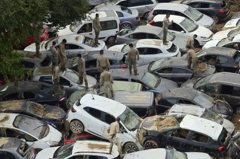 Veteranos buscan coches destrozados por las inundaciones en Massassana, región de Valencia.