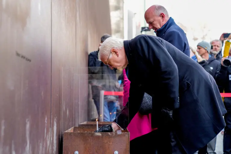 El presidente alemán, Frank-Walter Steinmeier, enciende una vela con motivo del 35º aniversario del muro en Berlín.