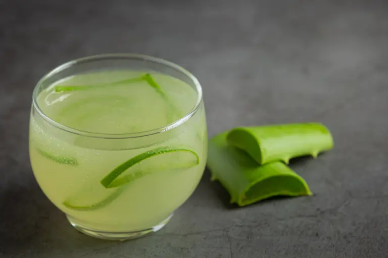a glass of aloe vera  juice put on dark floor