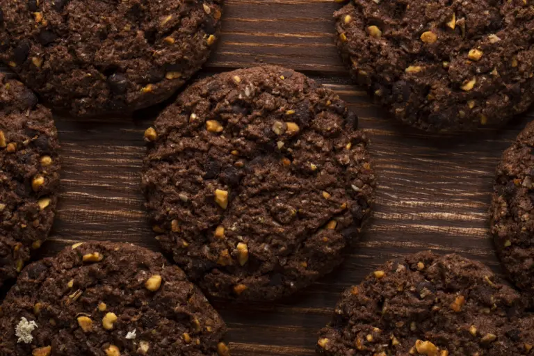 top view of chocolate chip cookies with cereals nuts and cocoa on wooden background